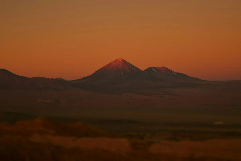a mountain range is shown with a sunrise in the background