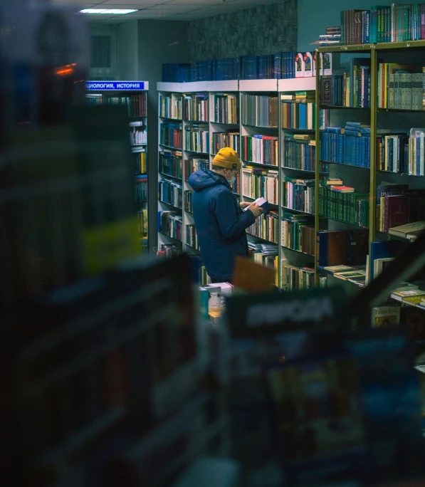 a man that is standing in front of a bookshelf