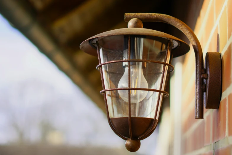 an old - fashioned wall light mounted against a brick building