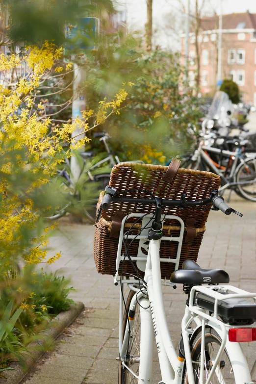 a bike with a wicker basket parked in a city