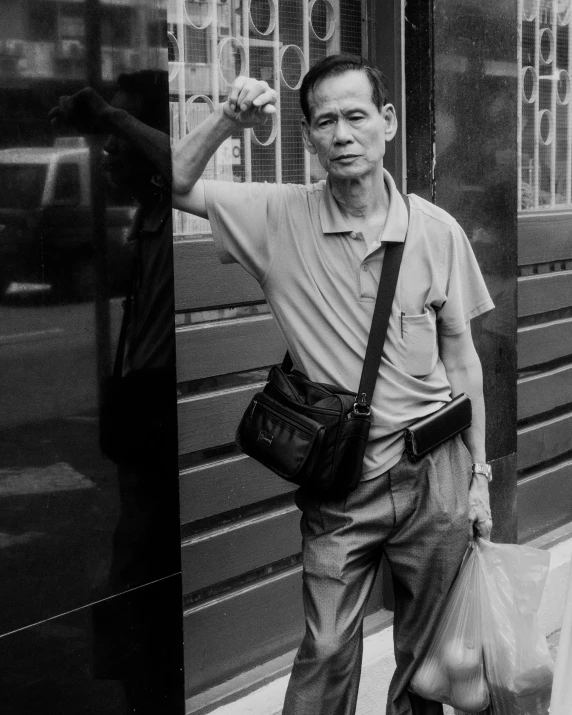a black and white po of a man in a shirt holding two bags