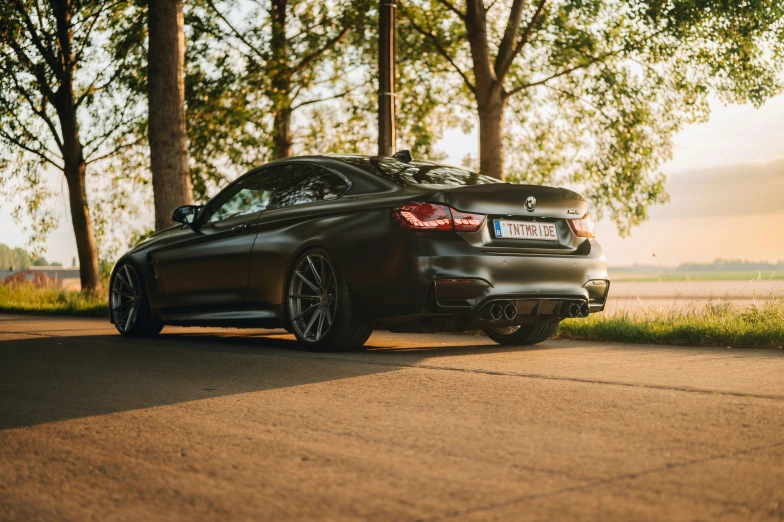 the back end of a black sports car on a street