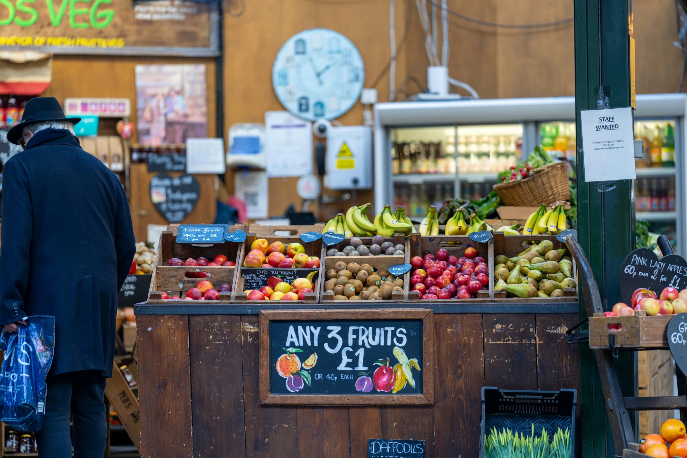 a man standing in front of a fruit stand