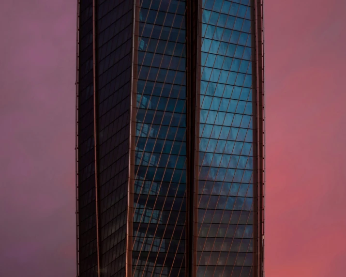 the windows on a building are reflecting a pink sky