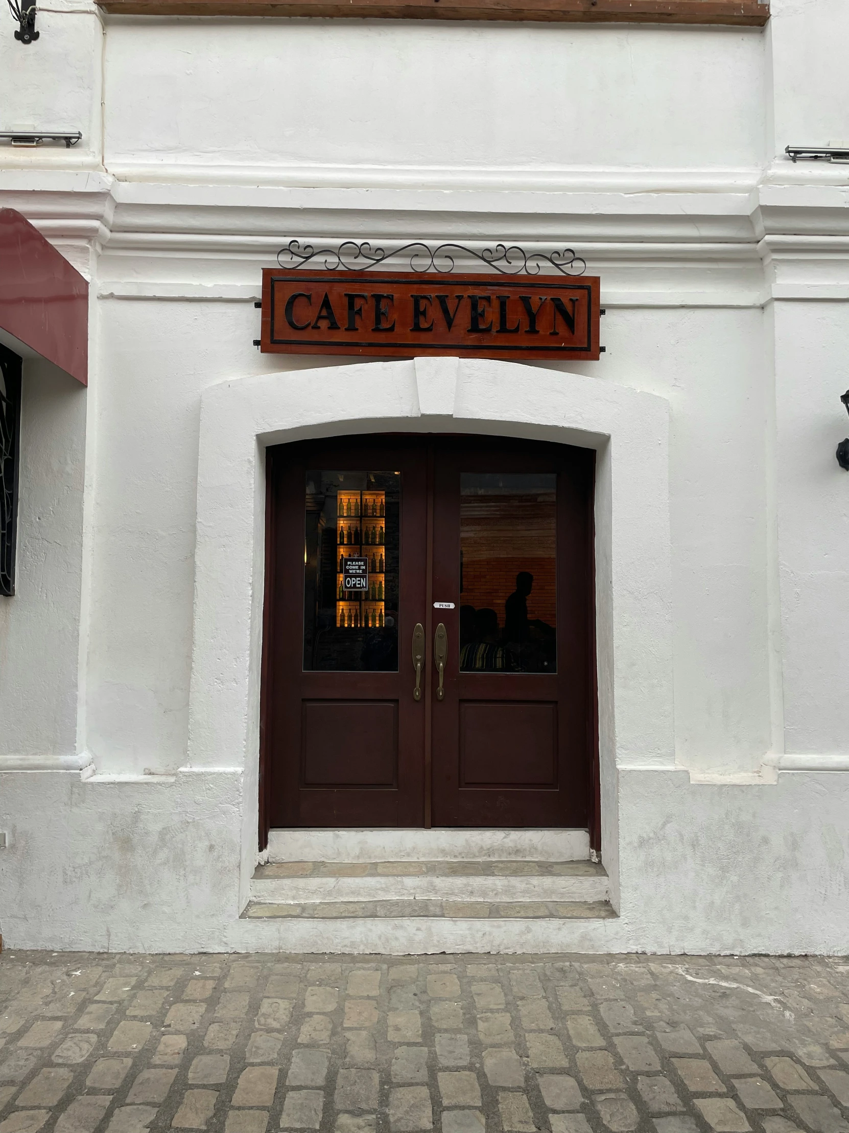 a tall white building with brown wooden doors