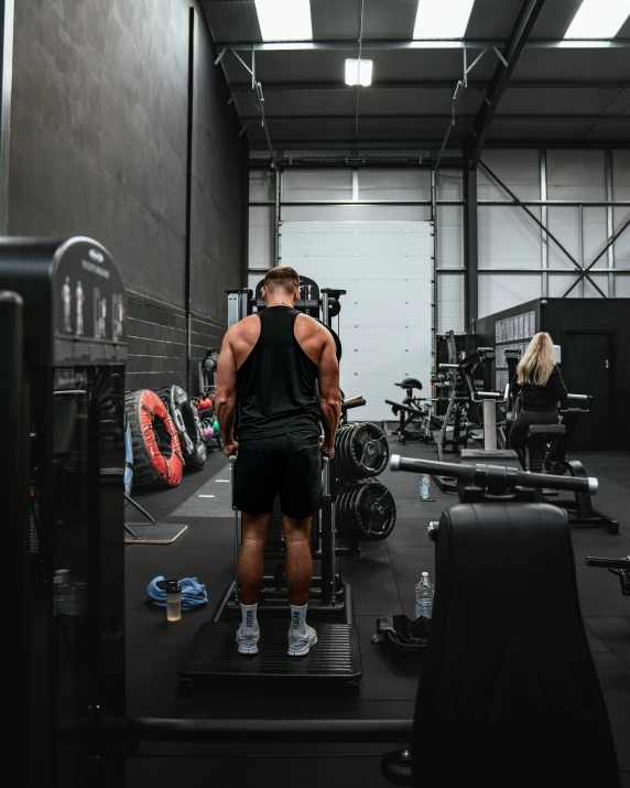 man with his back turned doing heavy lifting