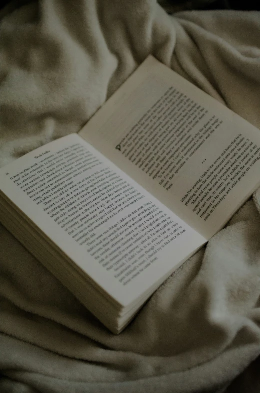 an open book is laying on a bed