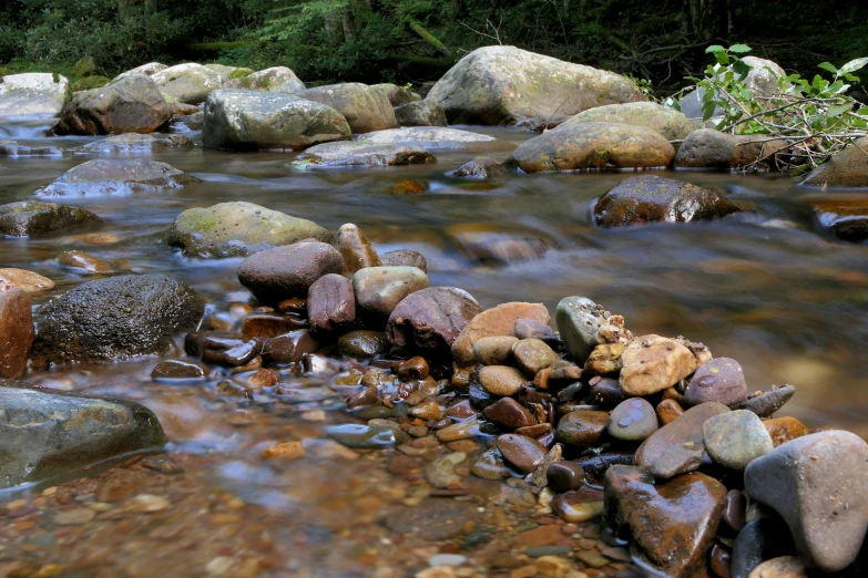 several rocks are on a river and have some water