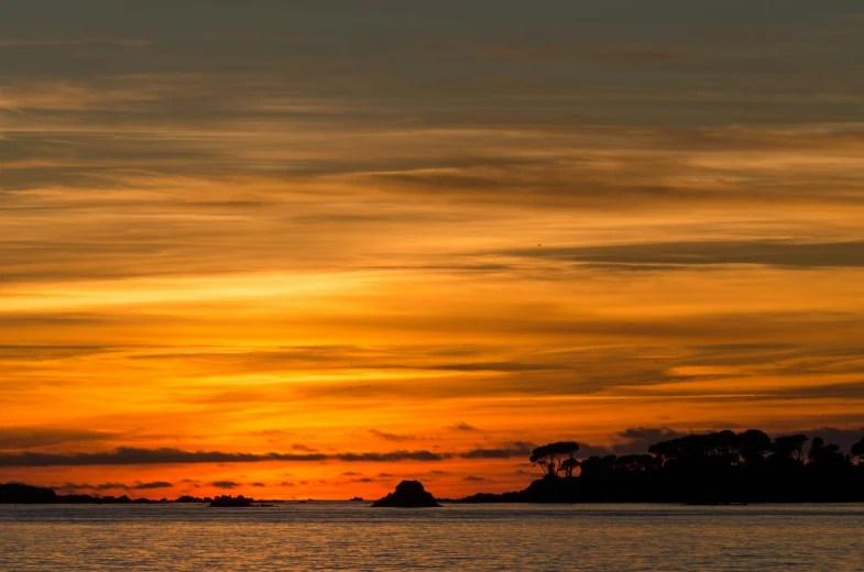 a body of water with several large waves at sunset