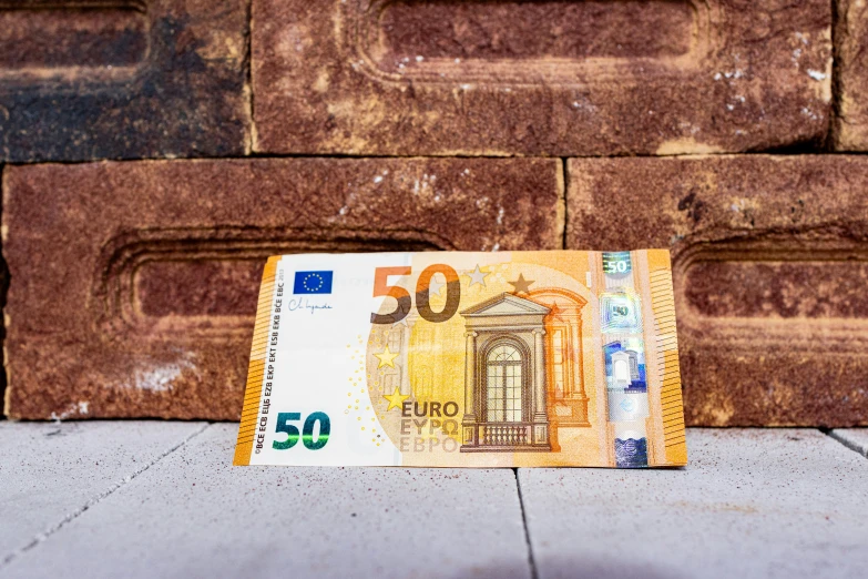 a 50 euros bill laying on top of concrete