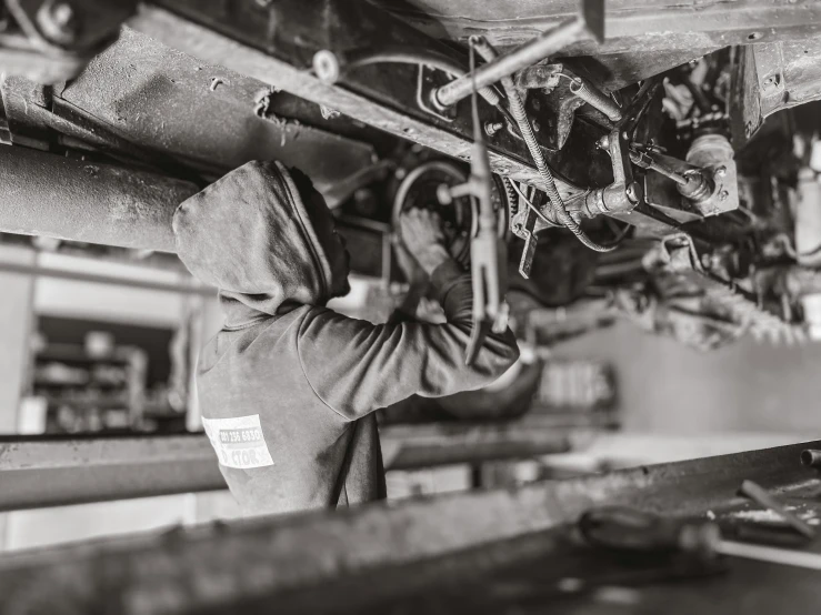 a person in hoodie holding onto metal bars on top of machine