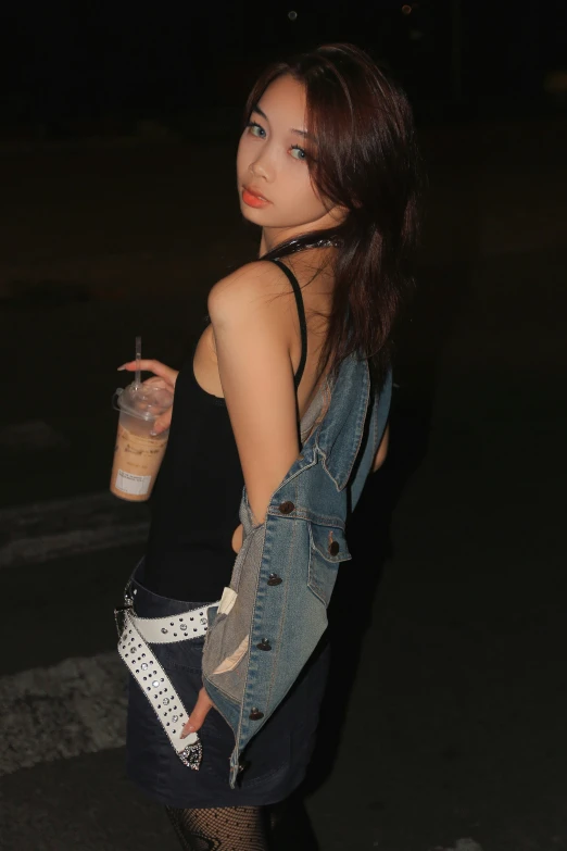 a beautiful young woman holding a drink and wearing tight clothing