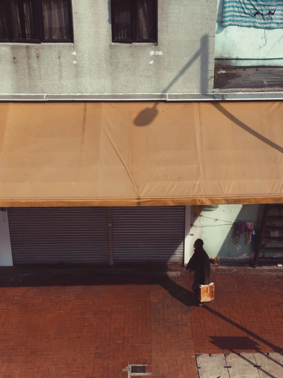 a man walks by a building with awnings on the street