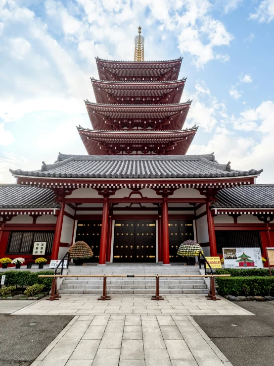 a tall building has a small pagoda behind it