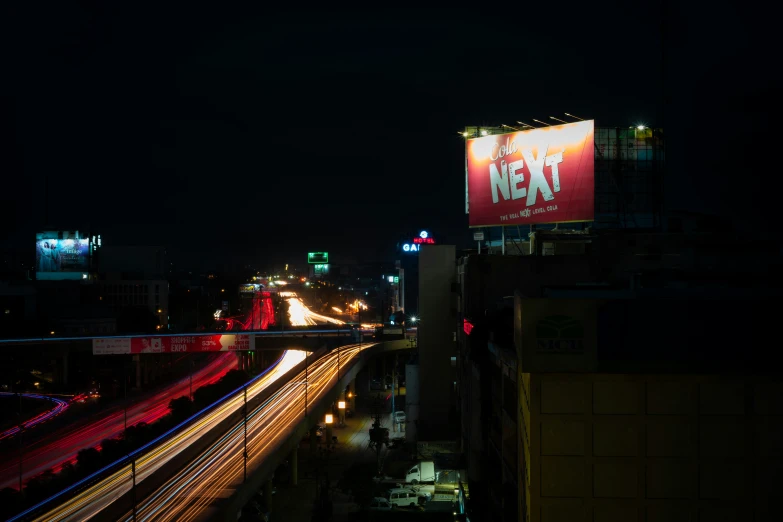 large electronic sign with city light and light trails