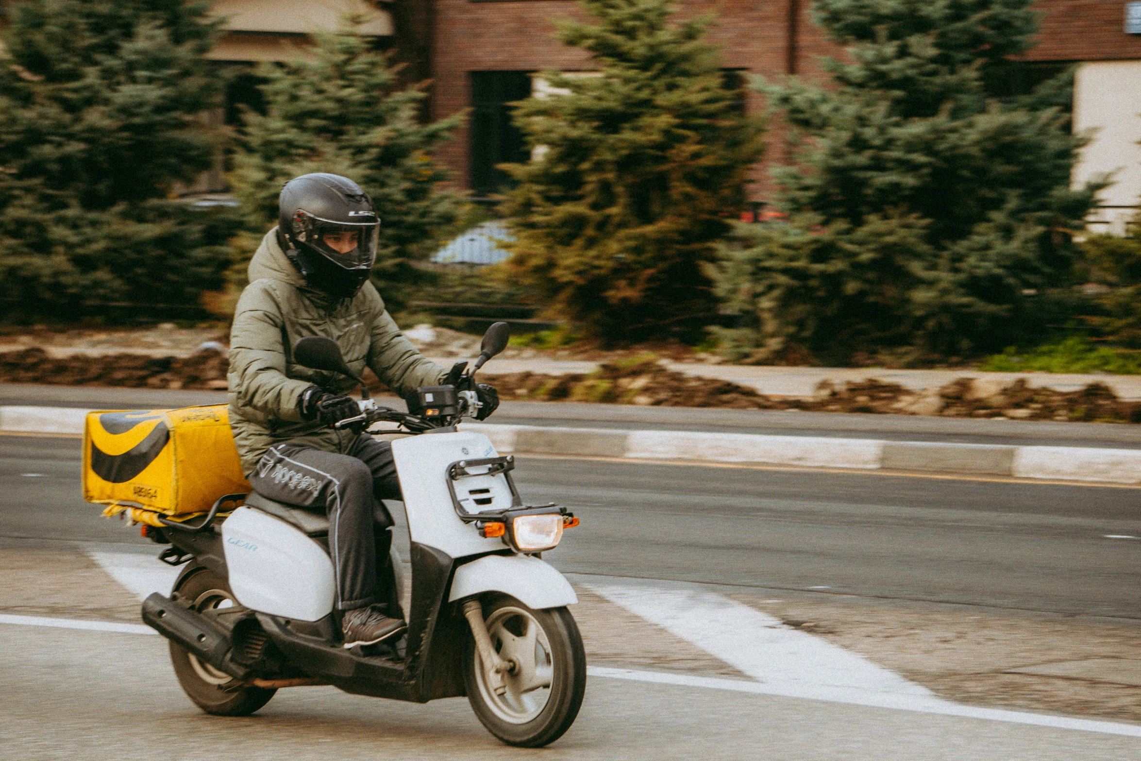 a man in helmet riding a motorcycle on road