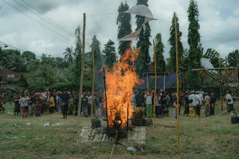 a large group of people standing around a fire