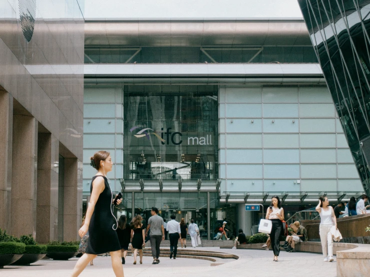 people walk past the large entrance to a large building