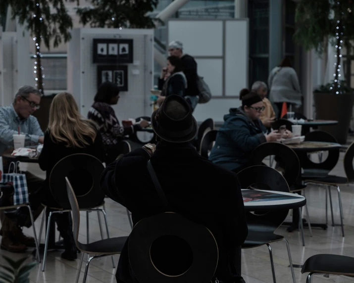 people are sitting at tables and eating food