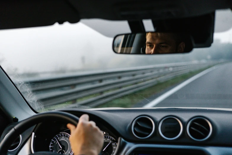 a man in a car is driving on the street