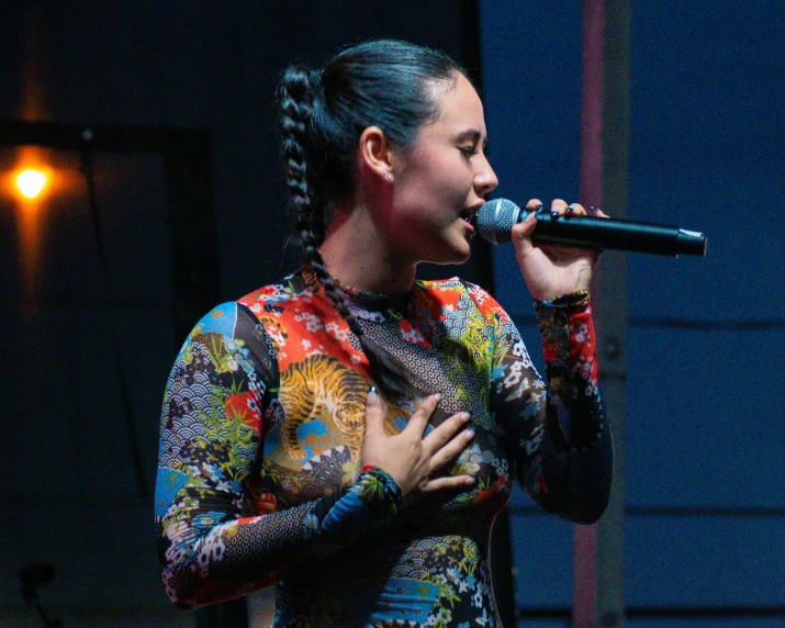 a woman holding a microphone and looking up into the sky