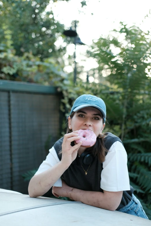 a woman that is holding a doughnut in her hand