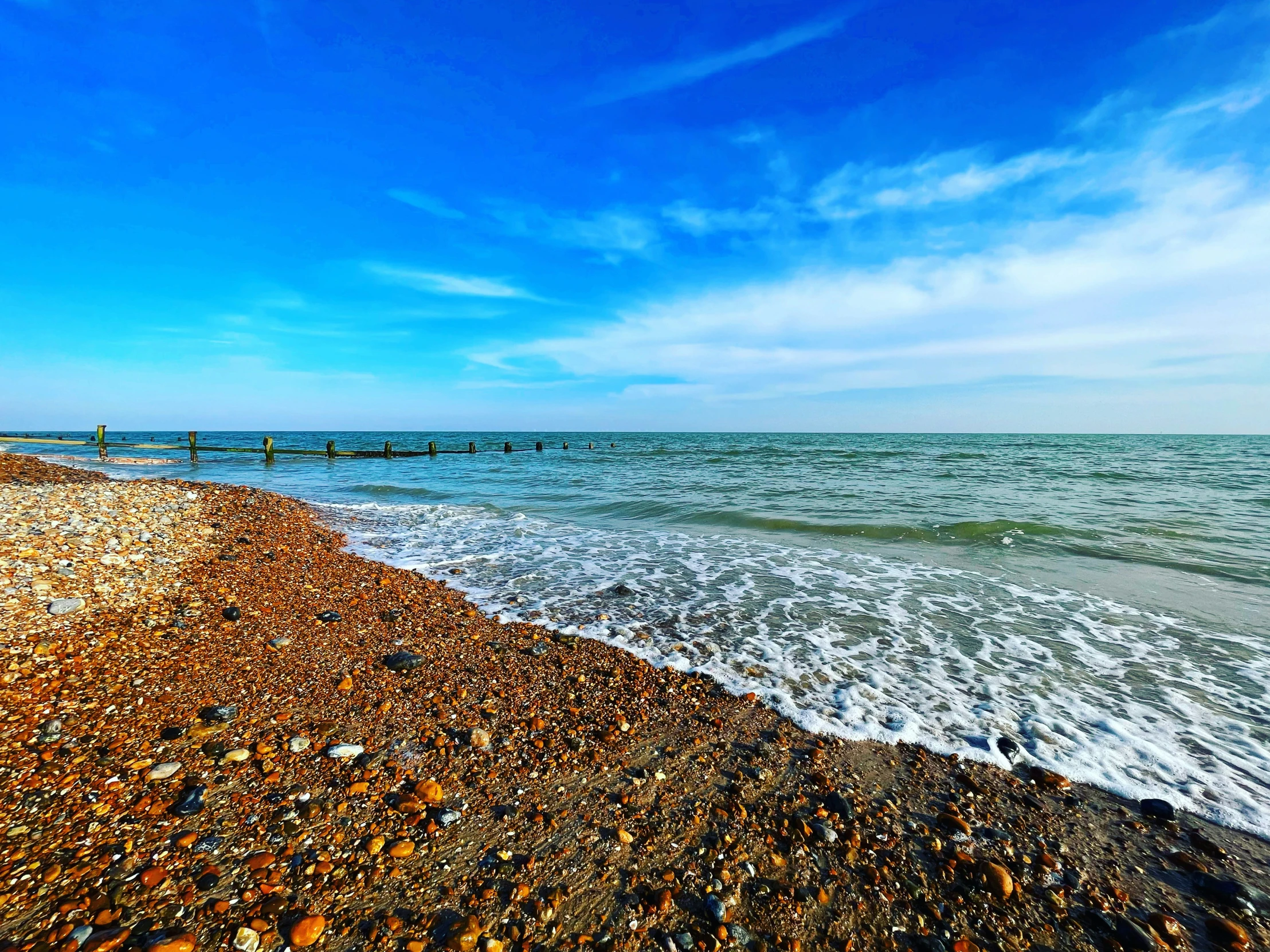 a beach with large waves and rocks at the shore