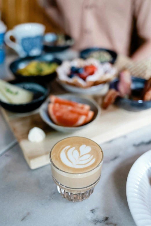 a person preparing a meal with coffee and fruit on the table