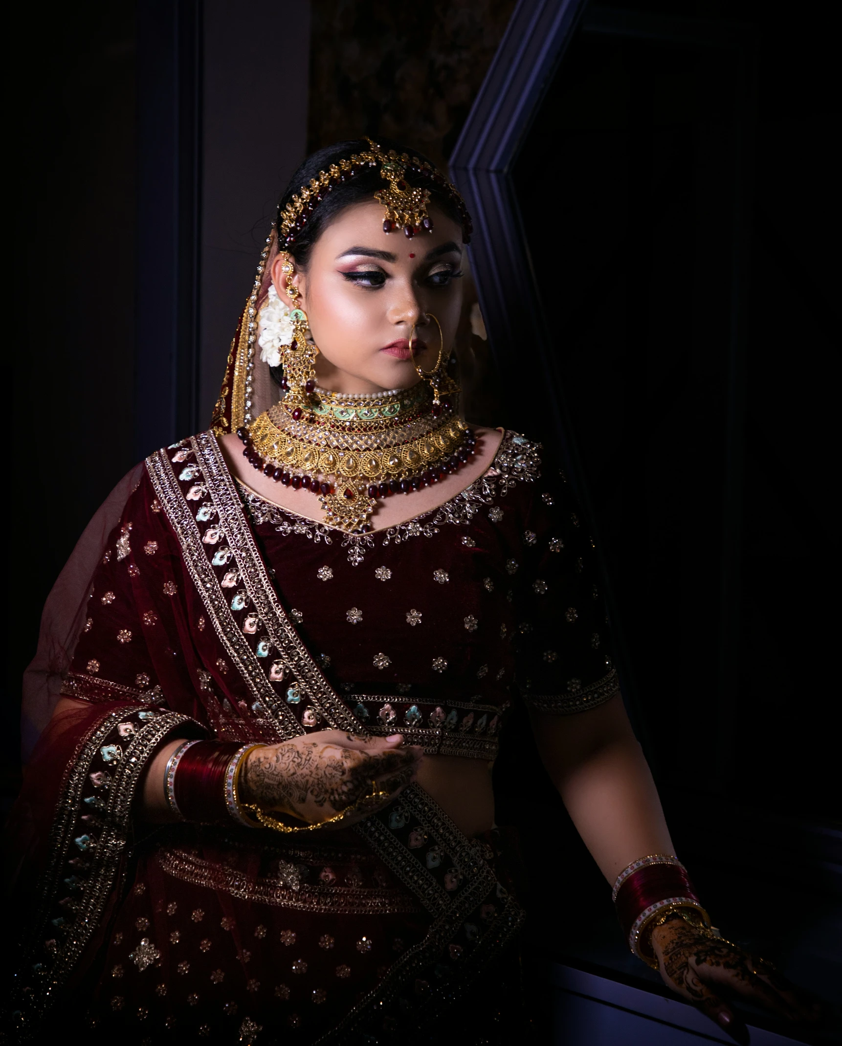 a woman wearing a red bridal and jewelry