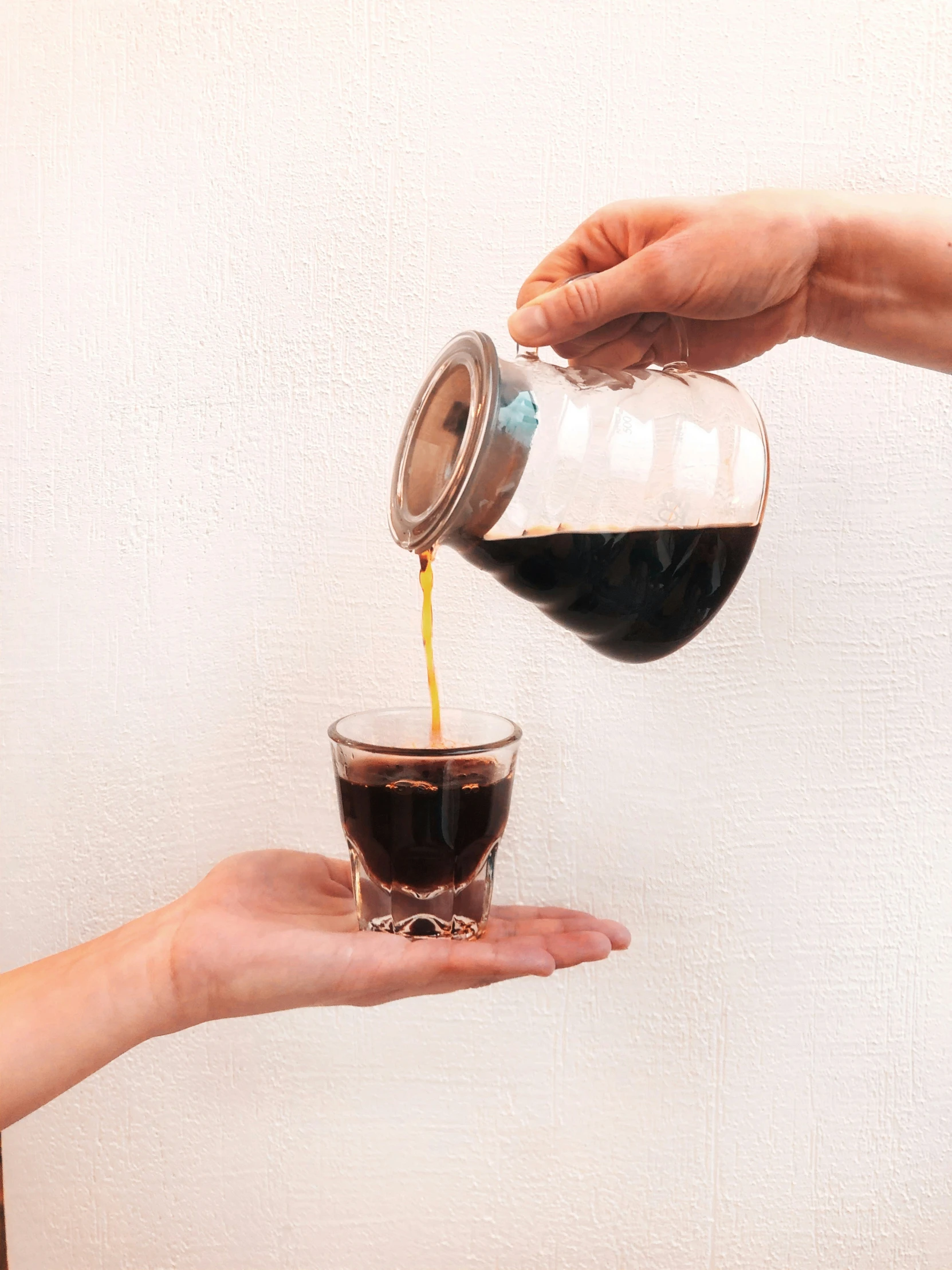 someone pouring soing into a glass of liquid