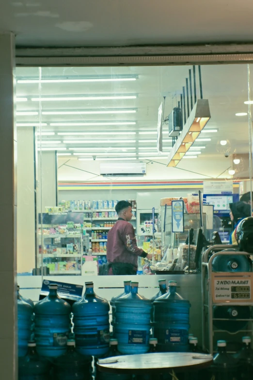 people at a store with large blue water tanks