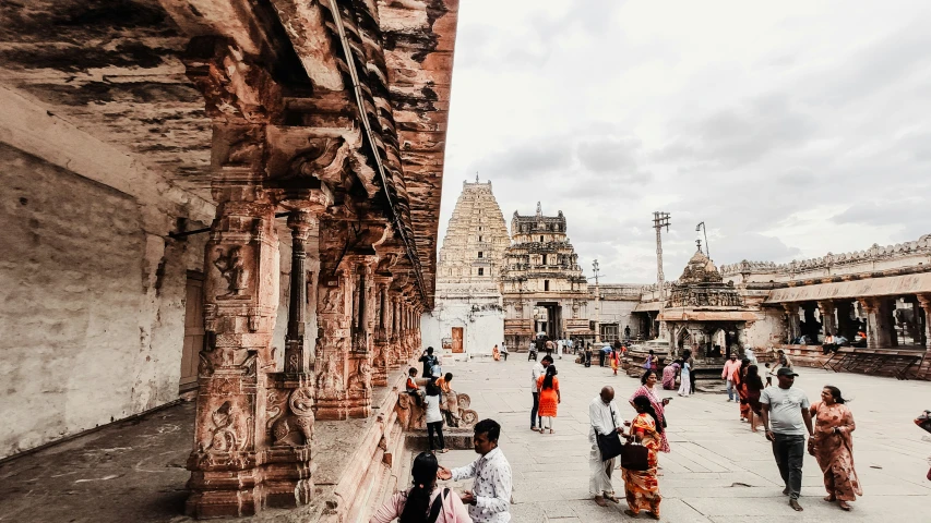 people walk around a narrow outdoor area in india