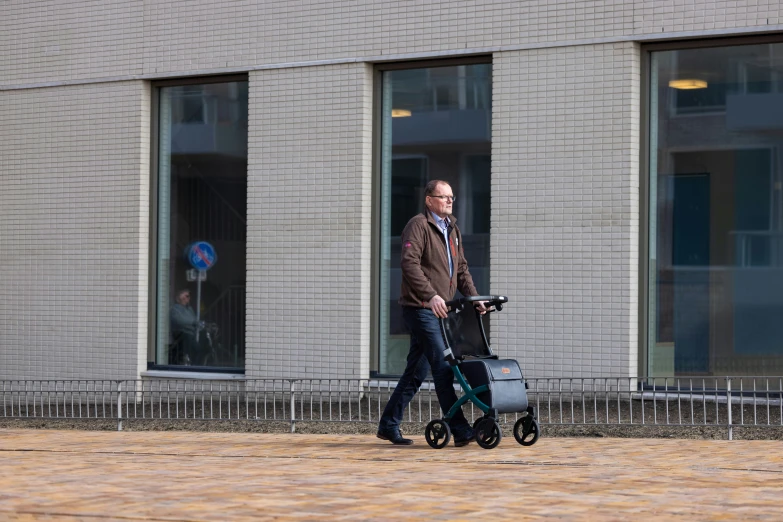 a man in the middle of an empty area, with a rolling luggage cart