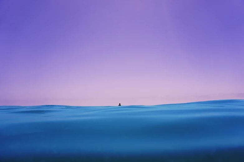 the ocean is clear and blue with a person standing on a surf board