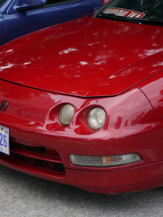 the hood of a red sports car with chrome wheels