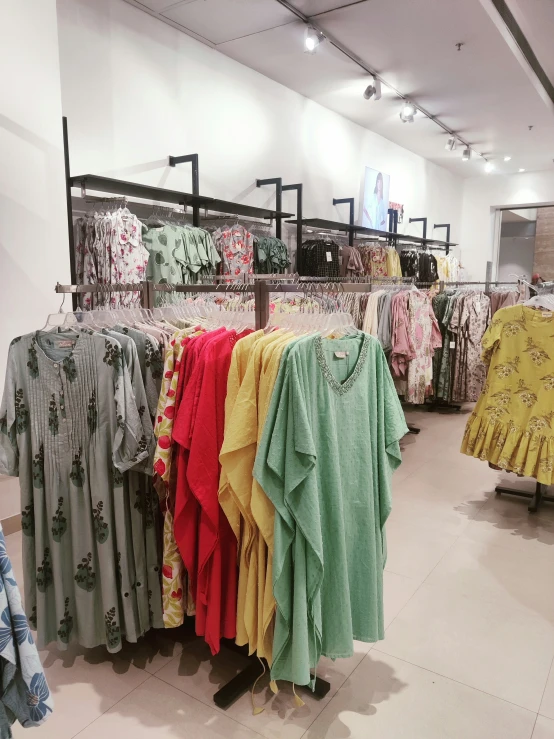 there is a variety of colorful clothing hanging in the store