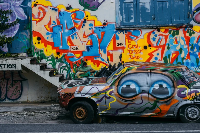 the old car has been covered with graffiti