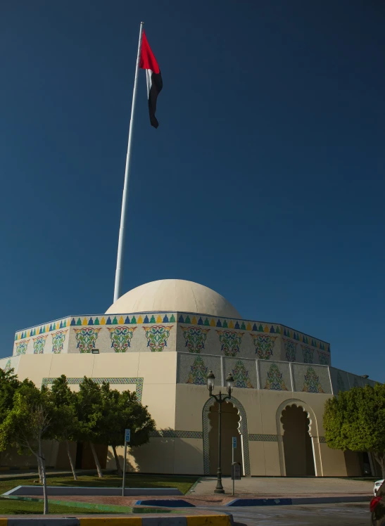 the dome is behind a flag pole in the park