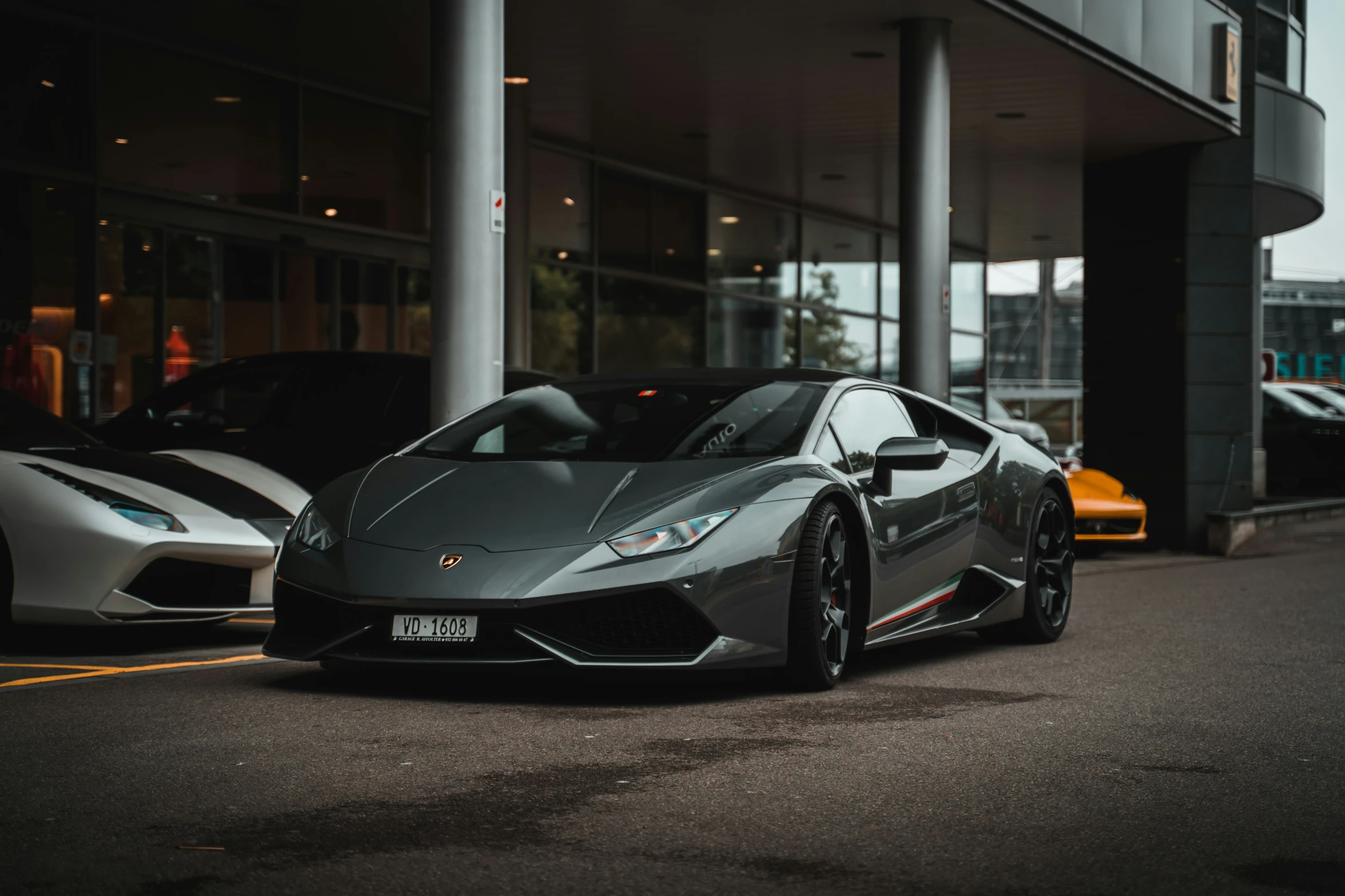 a grey car is parked next to other cars