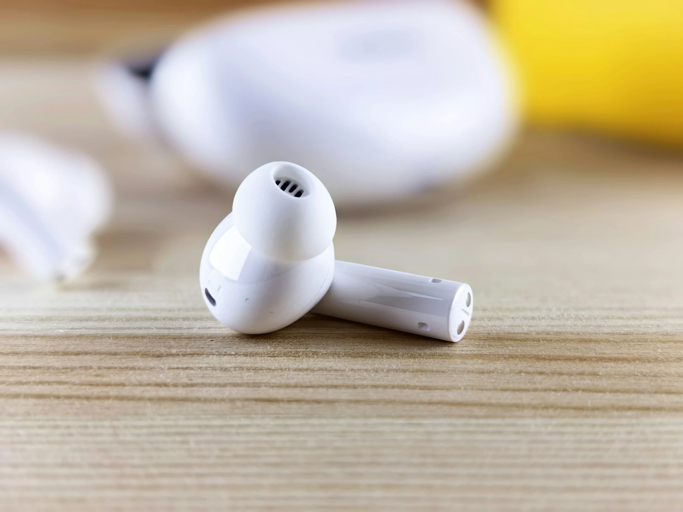 a pair of earphones lie on a wooden table