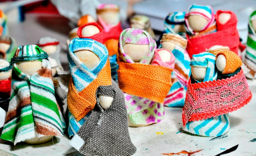 small colorful dolls sit in baskets on a table