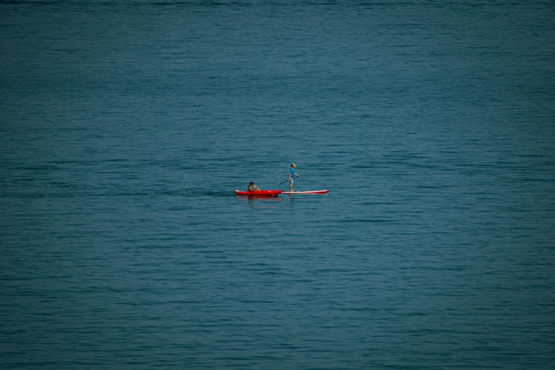 a small red canoe with two people inside