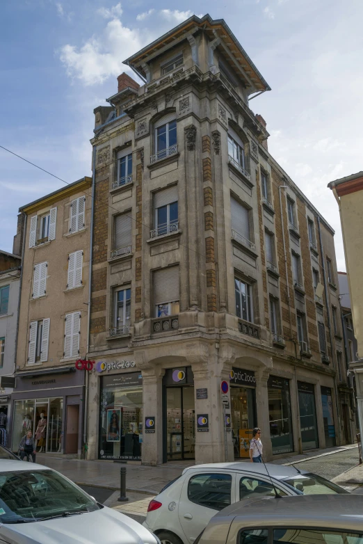 a building with some cars and people walking around