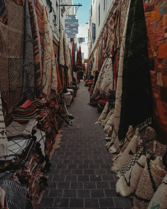 a wide pathway filled with blankets and rugs in an oriental city