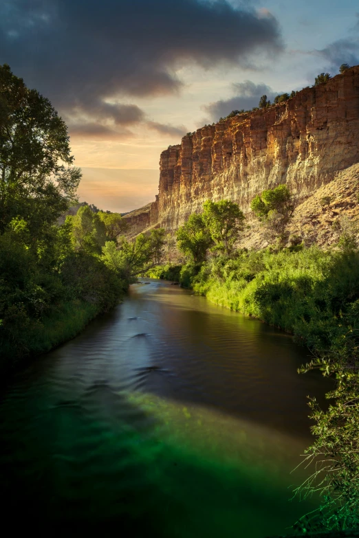 a beautiful river surrounded by mountains with greenery