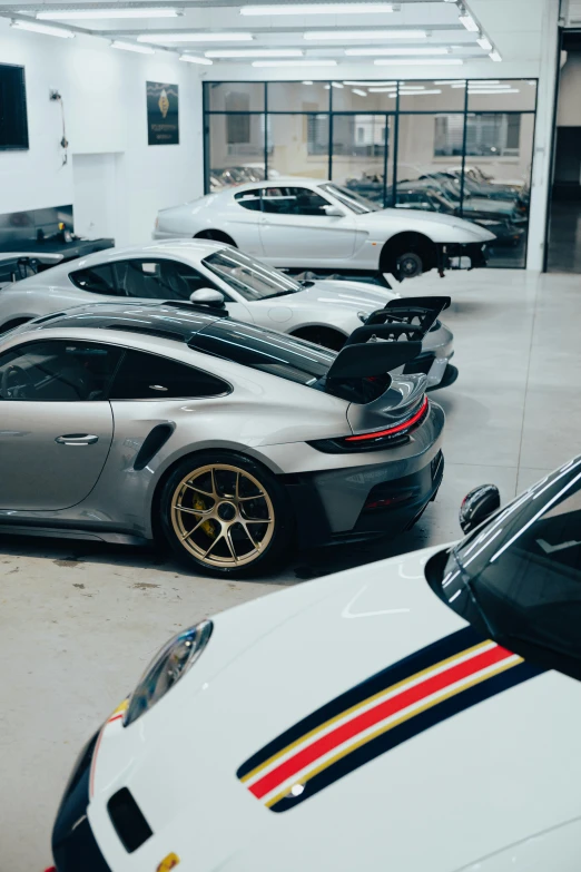 a porsche gt3 in the garage with several different color options