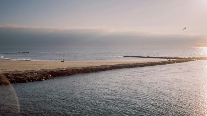 a pier is next to the water as people walk on it