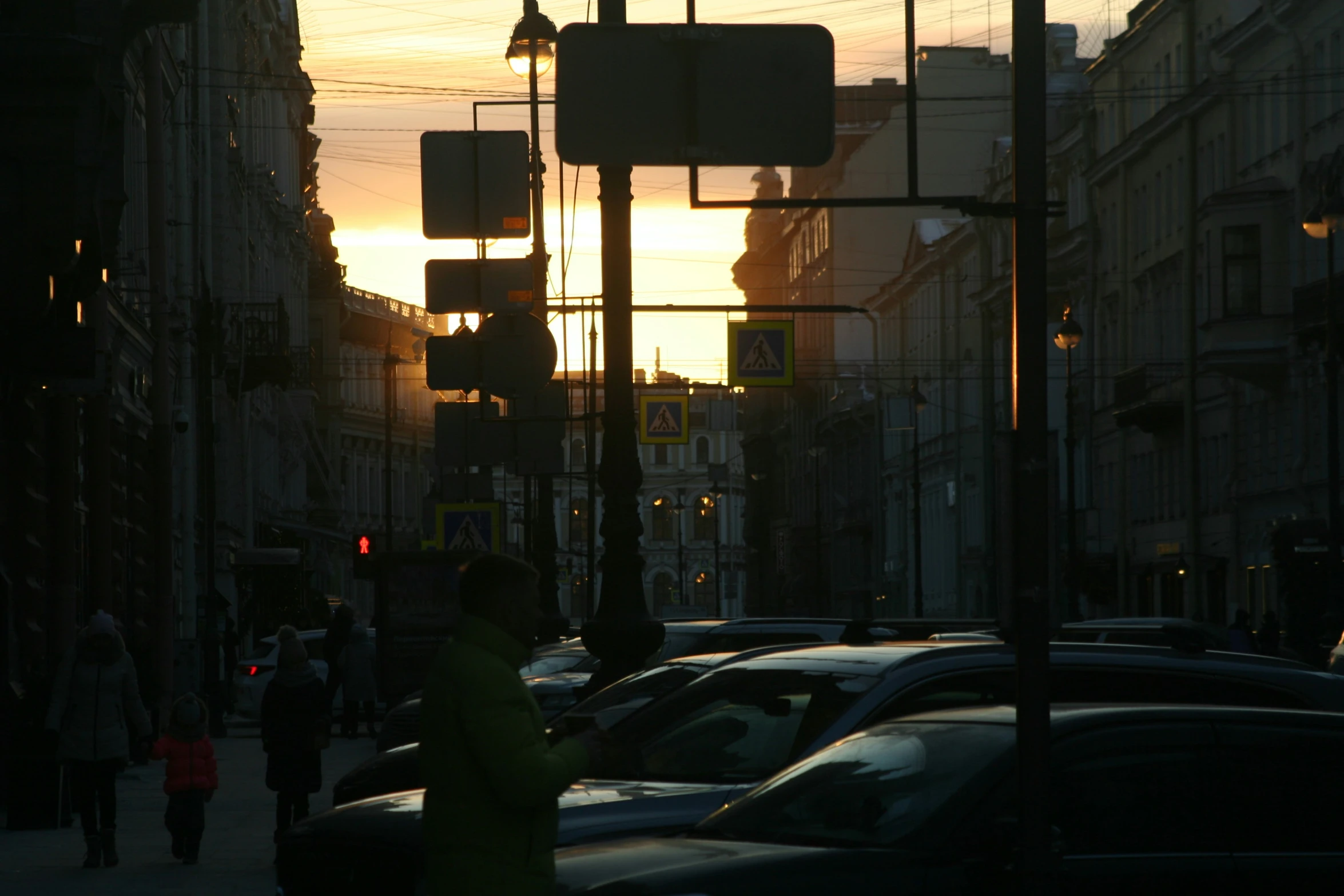 sunset on an intersection with traffic lights and buildings