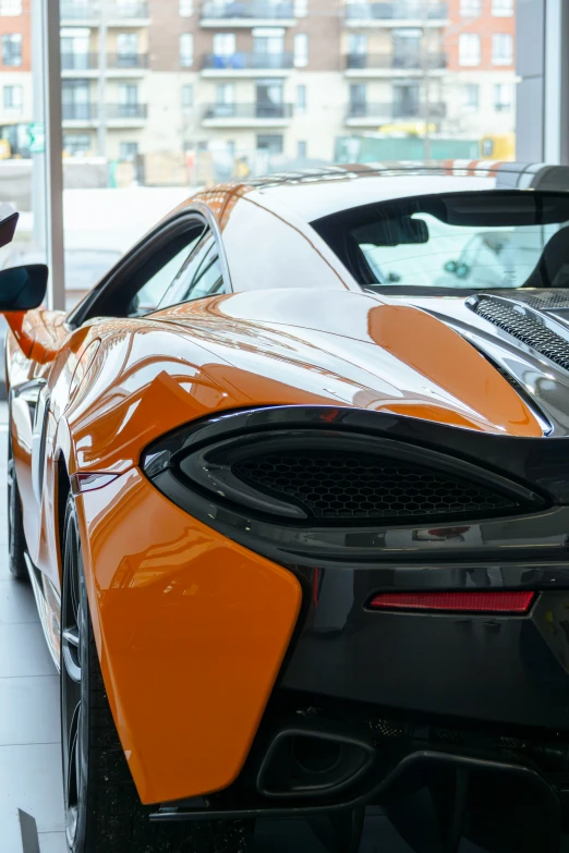 the orange sports car is parked next to another car