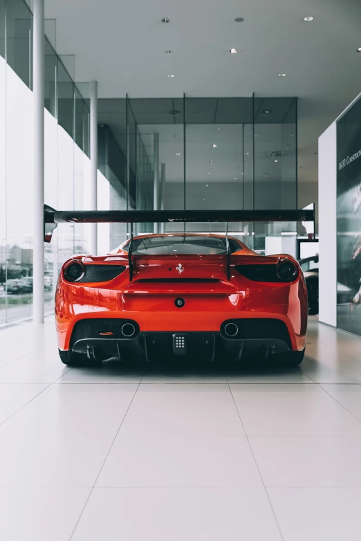 an orange sports car is parked inside of the building